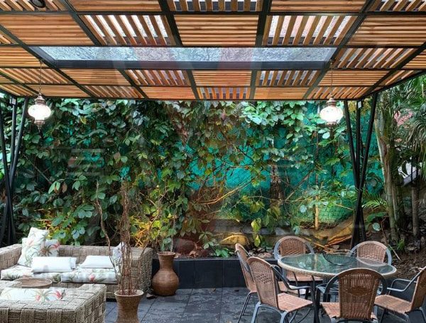 Pérgola en vidrio templado con difusores en madera
